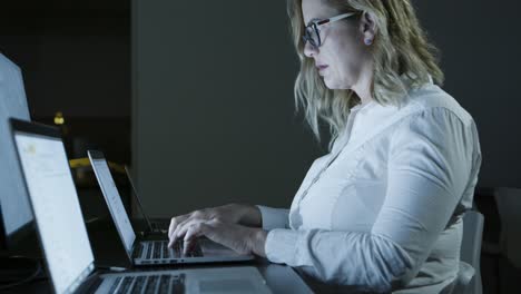 Focused-businesswoman-in-eyeglasses-using-computer